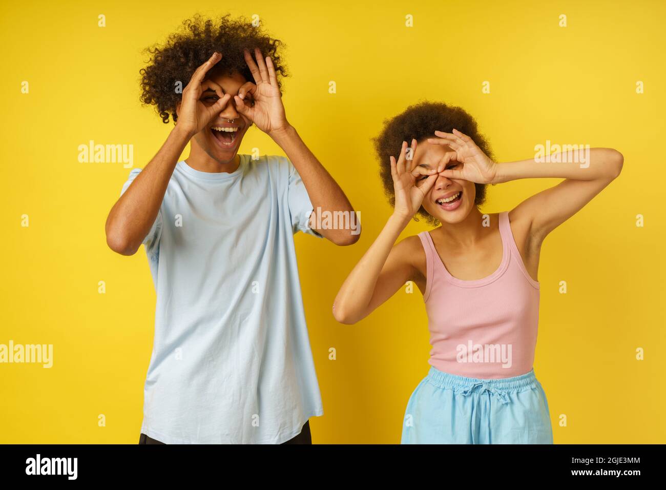 Couple heureux blague en faisant des lunettes avec leurs mains Banque D'Images