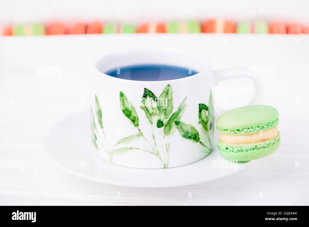 Tasse en porcelaine de thé de fleur de pois bleu thaïlandais et macaron ou macaron de menthe verte. Copier l'espace Banque D'Images