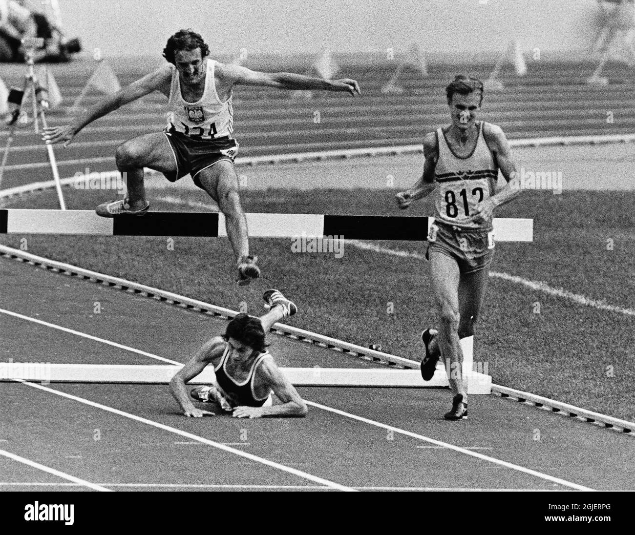 Anders Garderud springting pour la médaille d'or en steeplechase de 3000 mètres aux Jeux Olympiques de Montréal 1976. Baumgartl d'Allemagne de l'est vient de tomber sur le dernier obstacle et Malinowski de Pologne prend un saut sur lui courir pour l'argent. Banque D'Images