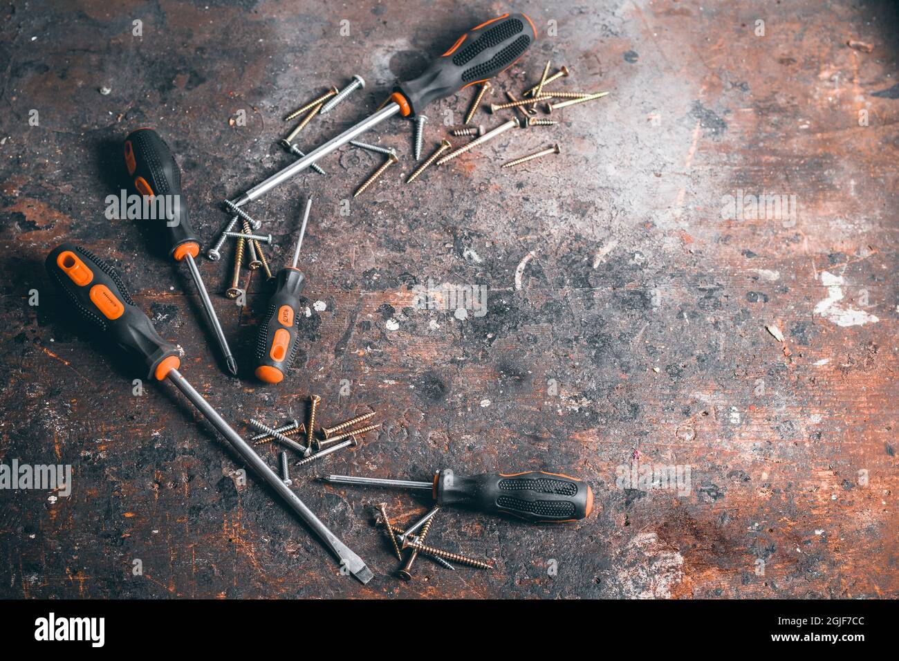 Tournevis et vis sur établi en bois. Vue de dessus des outils de travail avec espace pour le texte. Outils de construction sur table de travail en bois. Arrière-plan. Banque D'Images