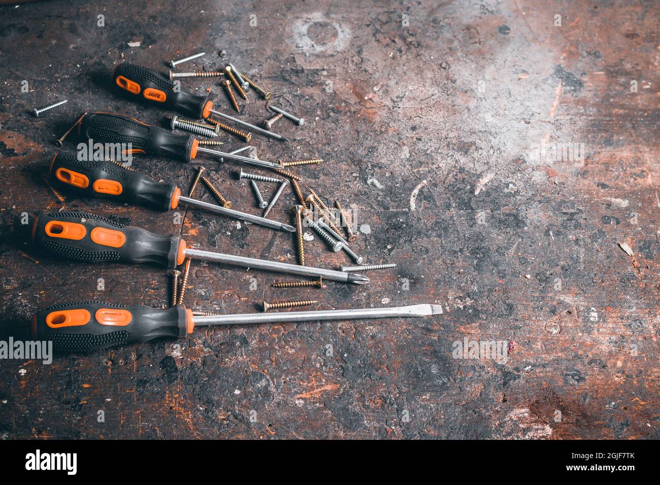 Tournevis et vis sur établi en bois. Vue de dessus des outils de travail avec espace pour le texte. Outils de construction sur table de travail en bois. Arrière-plan. Banque D'Images