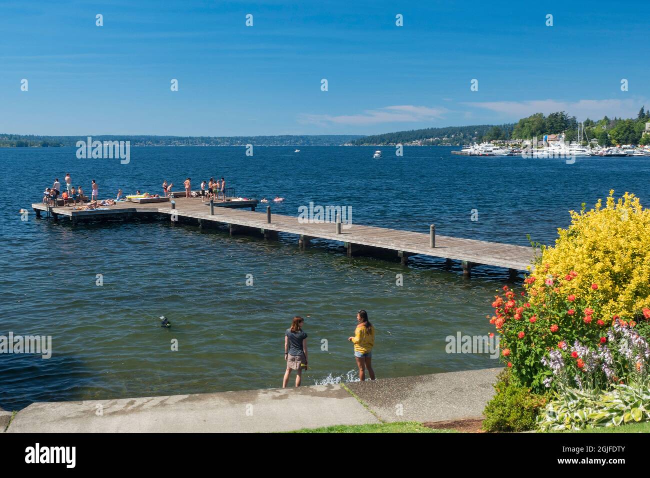 États-Unis, État de Washington, Kirkland, les femmes sur la rive et les gens se baignent au soleil sur le quai de Marsh Park. (Usage éditorial uniquement) (MR) Banque D'Images