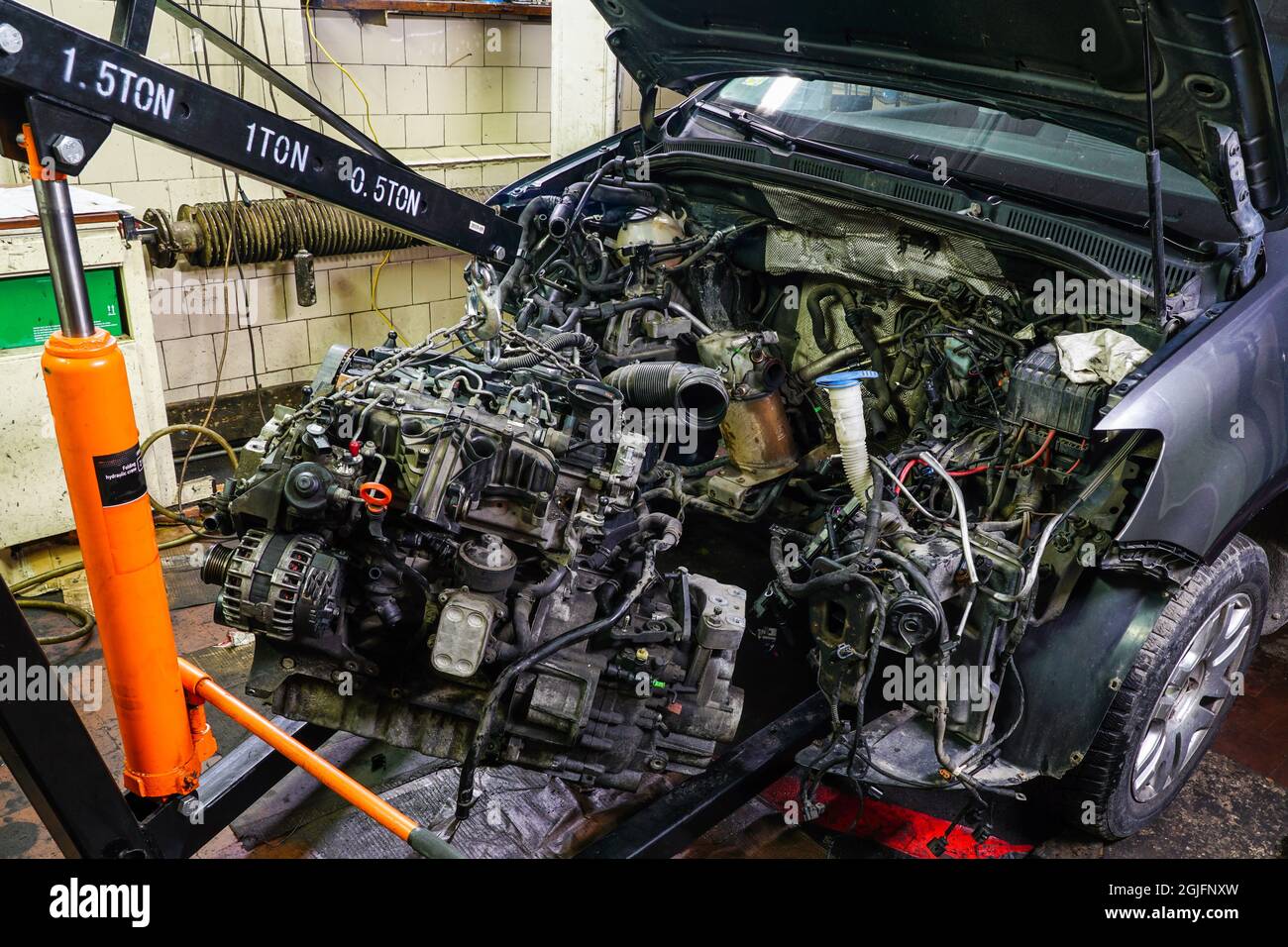 démontage d'un moteur endommagé d'une voiture à l'aide d'une grue  hydraulique repliable Photo Stock - Alamy