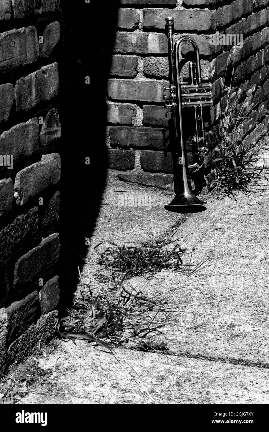 L'été, l'instrument de jazz trompette debout seul contre le mur de brique sur la rue de la ville Banque D'Images