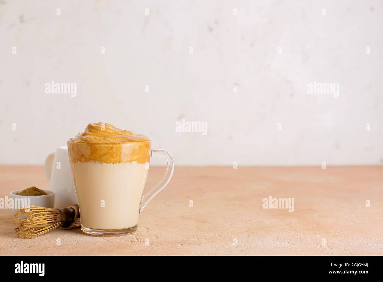 Tasse en verre de délicieux Dalgona hojicha latte et chasen sur table Banque D'Images