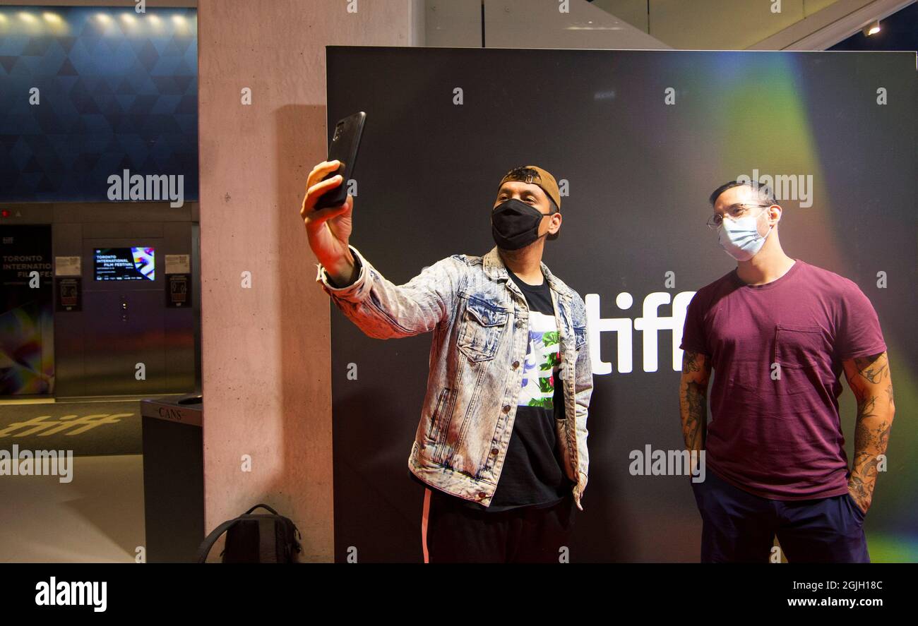 Toronto, Canada. 9 septembre 2021. Les personnes portant un masque facial prennent un selfie au siège de la visionneuse TIFF Bell du Festival international du film de Toronto (TIFF) 2021 à Toronto, Canada, le 9 septembre 2021. Le TIFF a été lancé jeudi, offrant des projections en intérieur, des drive-in, des cinémas en plein air et en ligne. Credit: Zou Zheng/Xinhua/Alamy Live News Banque D'Images