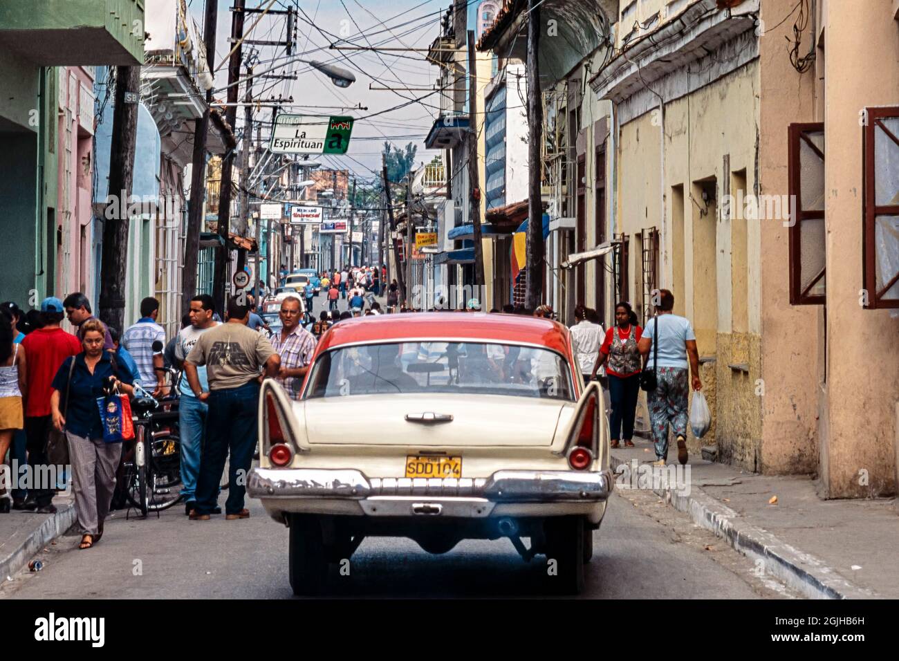 Voiture américaine classique avec des ailerons passant devant des piétons dans le centre-ville, Sancti Spiritus, Cuba Banque D'Images