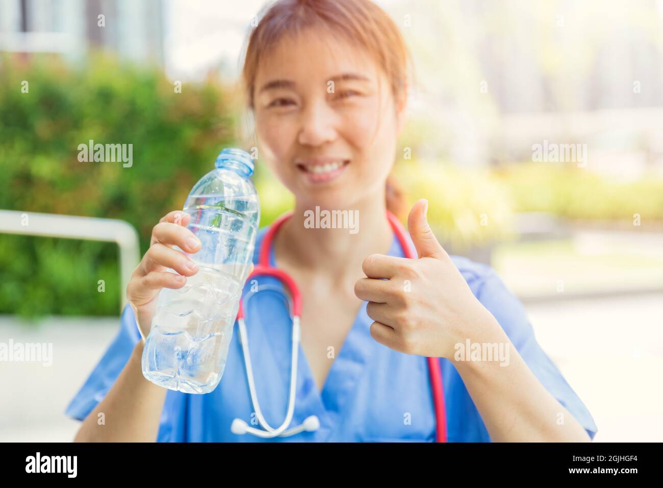 Médecin femme avec de l'eau potable pour une bonne santé en journée chaude pour un style de vie frais et sain. Banque D'Images