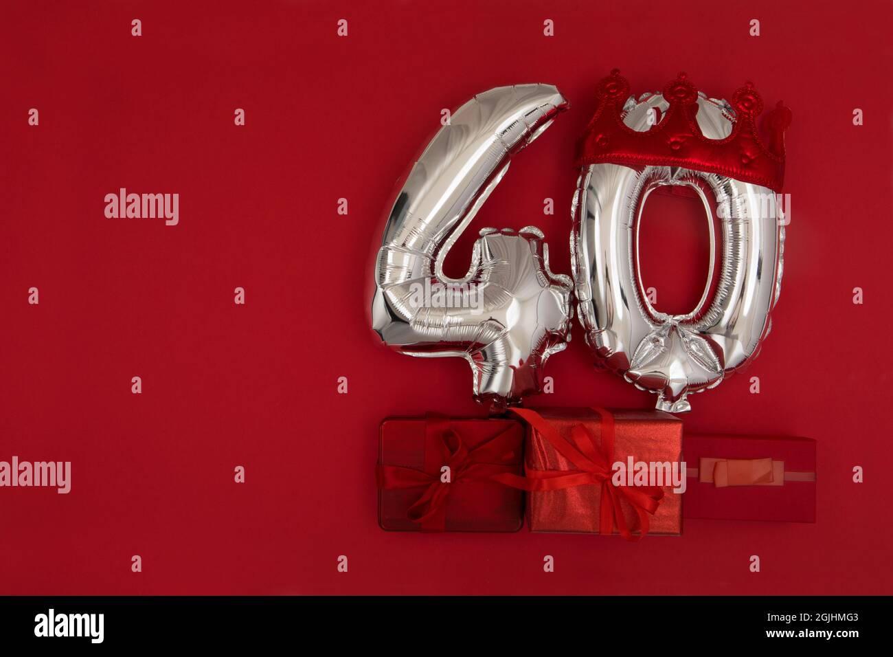 Ballons de numéro d'argent 40 quarante en couronne sur fond rouge foncé. Décoration de fête, concept de carte postale 40 avec vue sur le dessus Banque D'Images