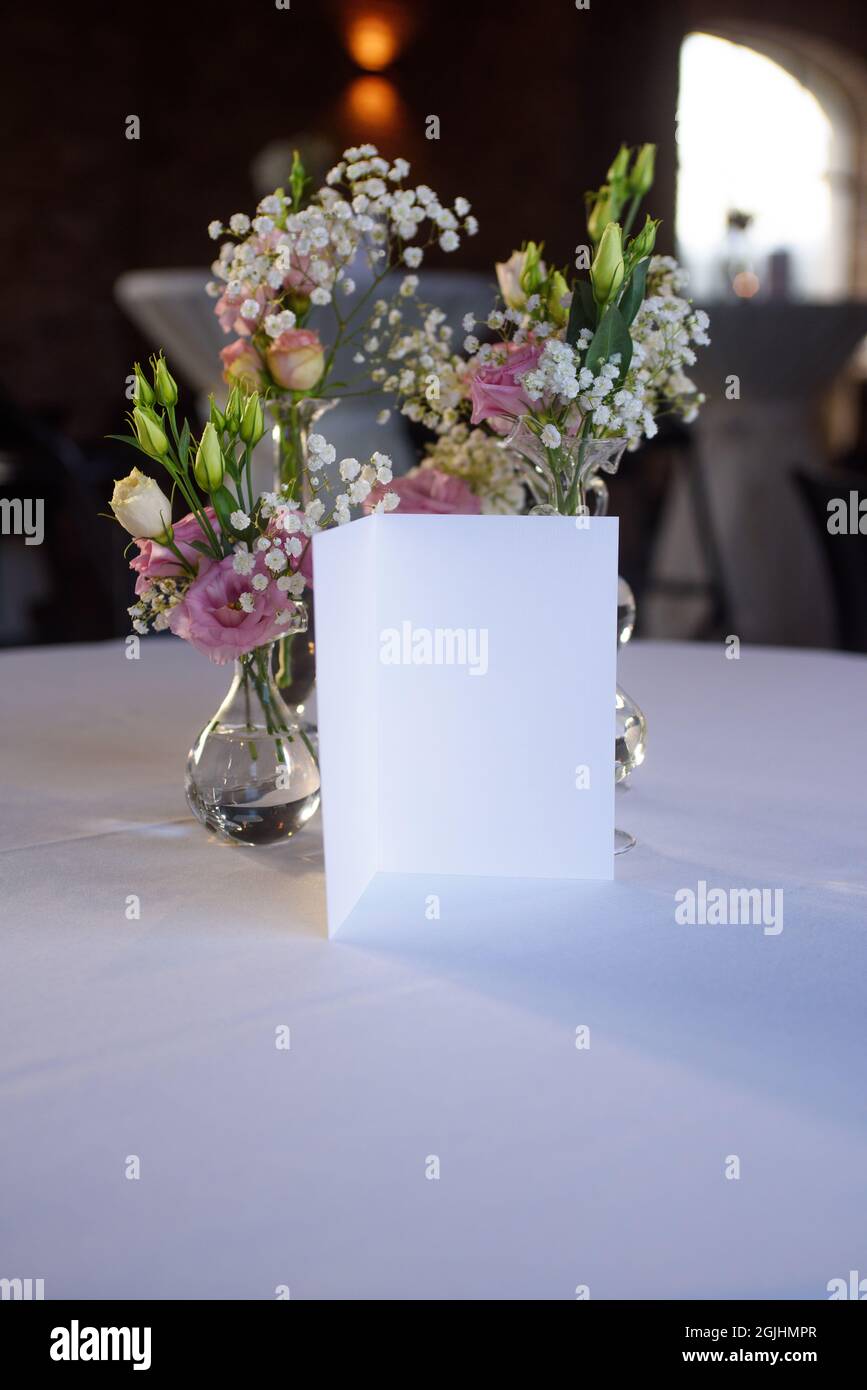 carte blanco avec fleurs sur une serviette blanche pour une fête sur un fond flou Banque D'Images
