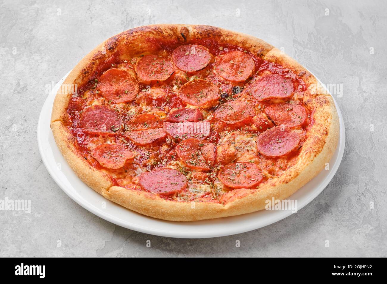 Pizza pepperoni de petite taille sur une assiette Banque D'Images