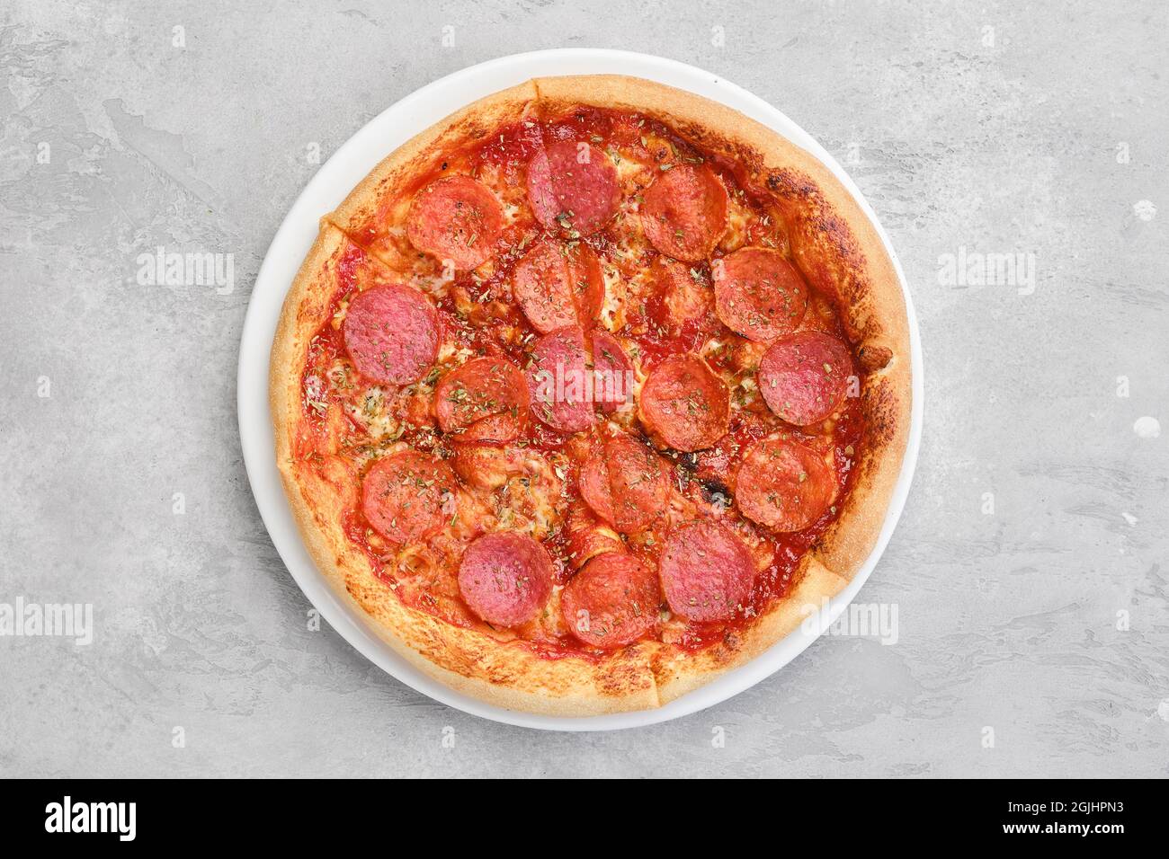 Vue en hauteur d'une petite pizza pepperoni sur une assiette Banque D'Images