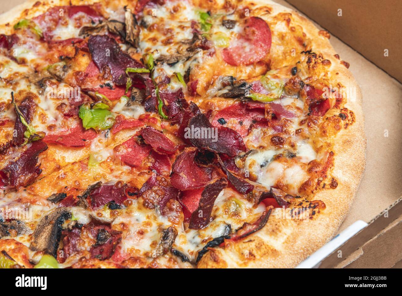 Vue de dessus de pizza chaude dans boîte à pizza recyclée. Banque D'Images