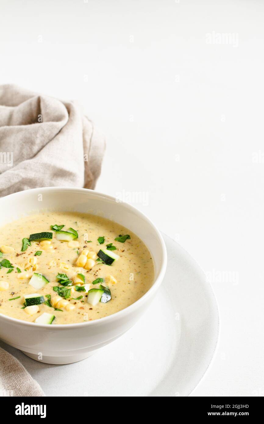 Bol de maïs et de courgette sur une assiette avec une serviette en lin. Banque D'Images