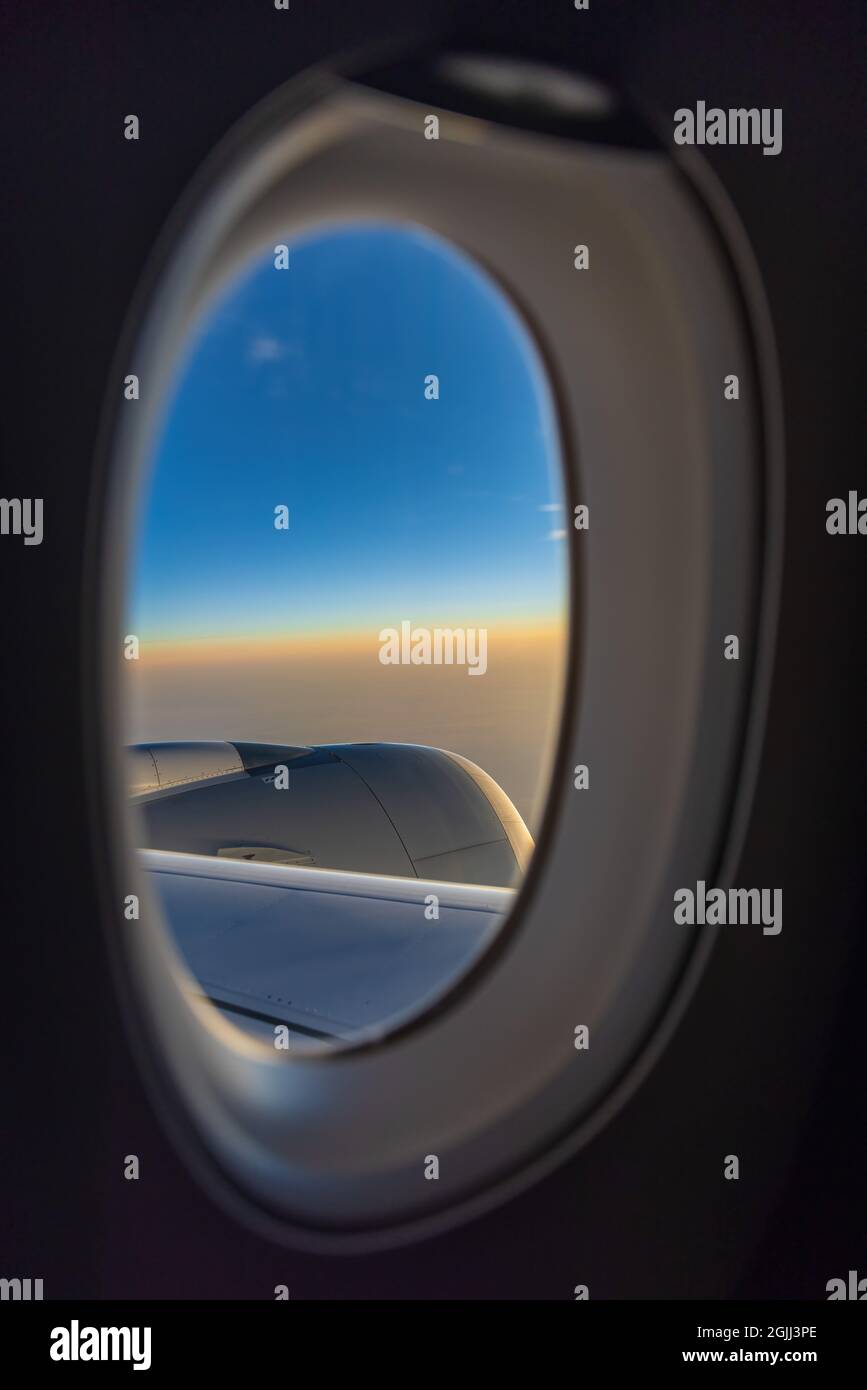 Vue sur le lever du soleil depuis un avion à fenêtre Banque D'Images