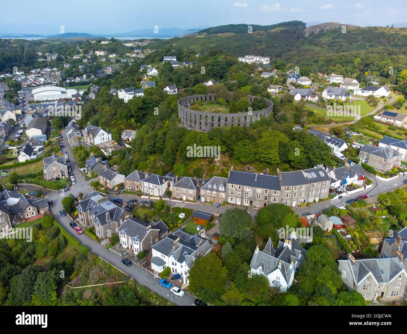 Vue aérienne depuis le drone de la tour McCaig et les maisons d'Oban, Argyll et Bute, Écosse, Royaume-Uni Banque D'Images