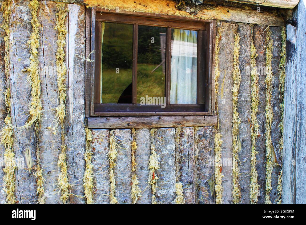 Gros plan d'une fenêtre dans le mur d'une cabine en rondins. Banque D'Images