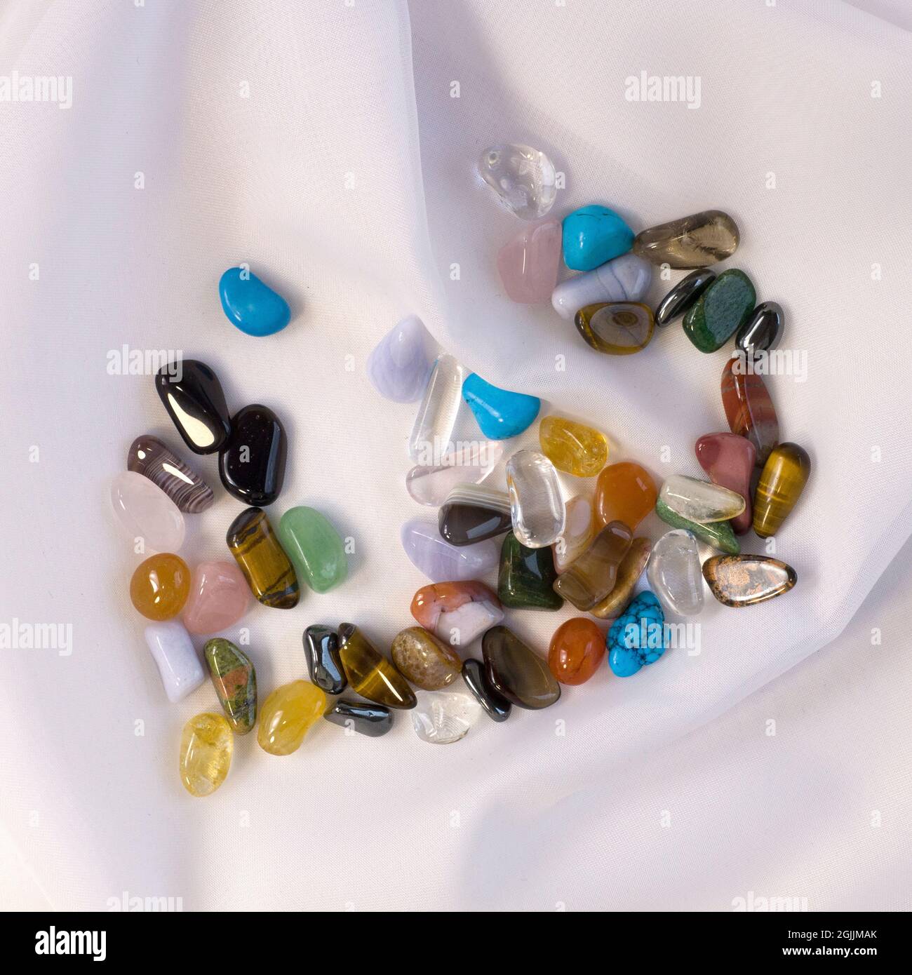 Collection de pierres précieuses semi-précieuses dans un petit pot en verre  sur fond de tissu texturé blanc gros plan plat Photo Stock - Alamy