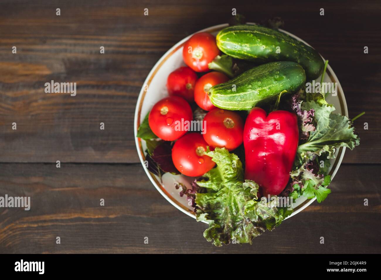 Autres légumes dans une assiette blanche sur une table en bois vue sur le dessus. Banque D'Images
