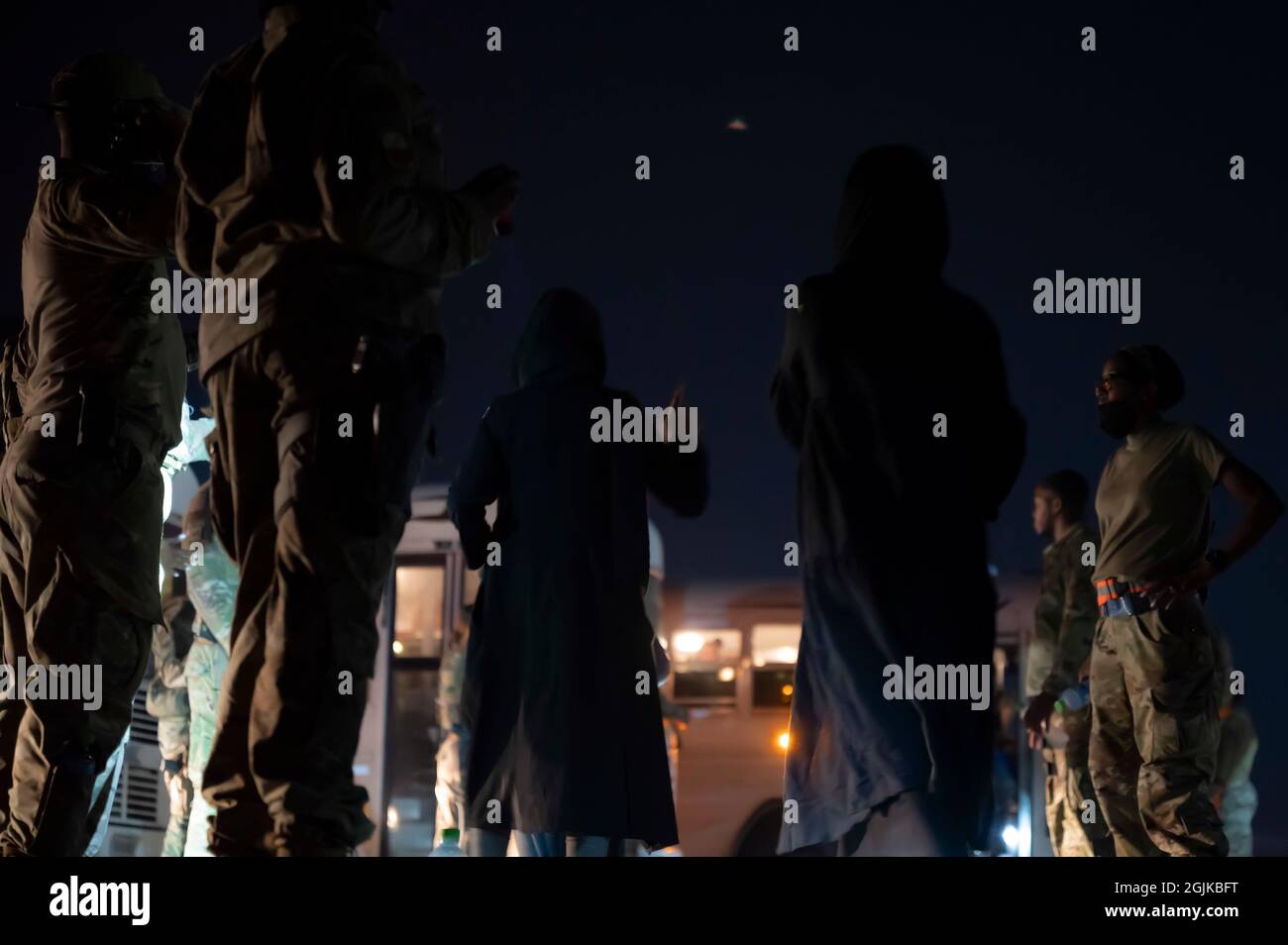 Des membres du 386e Escadron des forces de sécurité expéditionnaires escortent les évacués de l'Afghanistan après être arrivés à bord d'un avion C-17 Globemaster III à la base aérienne Ali Al Salem (Koweït), le 24 août 2021. Le ministère de la Défense s'est engagé à appuyer l'évacuation des citoyens américains, des demandeurs de visa spécial d'immigration et d'autres personnes à risque de l'Afghanistan. (É.-U. Photo de la Force aérienne par Tech. Sgt. Eric Summers Jr.) Banque D'Images
