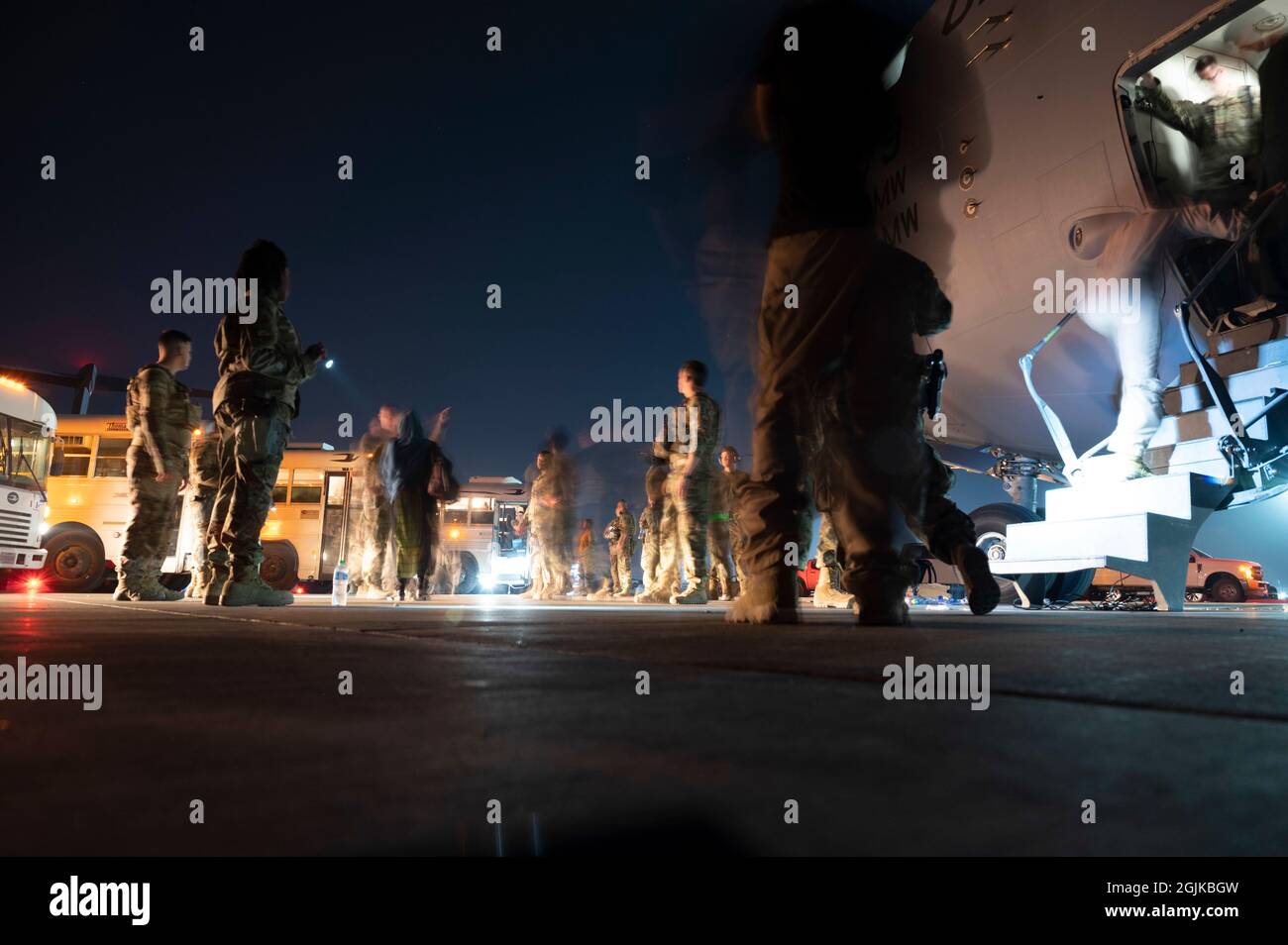 Des membres du 386e Escadron des forces de sécurité expéditionnaires escortent les évacués de l'Afghanistan après être arrivés à bord d'un avion C-17 Globemaster III à la base aérienne Ali Al Salem (Koweït), le 24 août 2021. Le ministère de la Défense s'est engagé à appuyer l'évacuation des citoyens américains, des demandeurs de visa spécial d'immigration et d'autres personnes à risque de l'Afghanistan. (É.-U. Photo de la Force aérienne par Tech. Sgt. Eric Summers Jr.) Banque D'Images