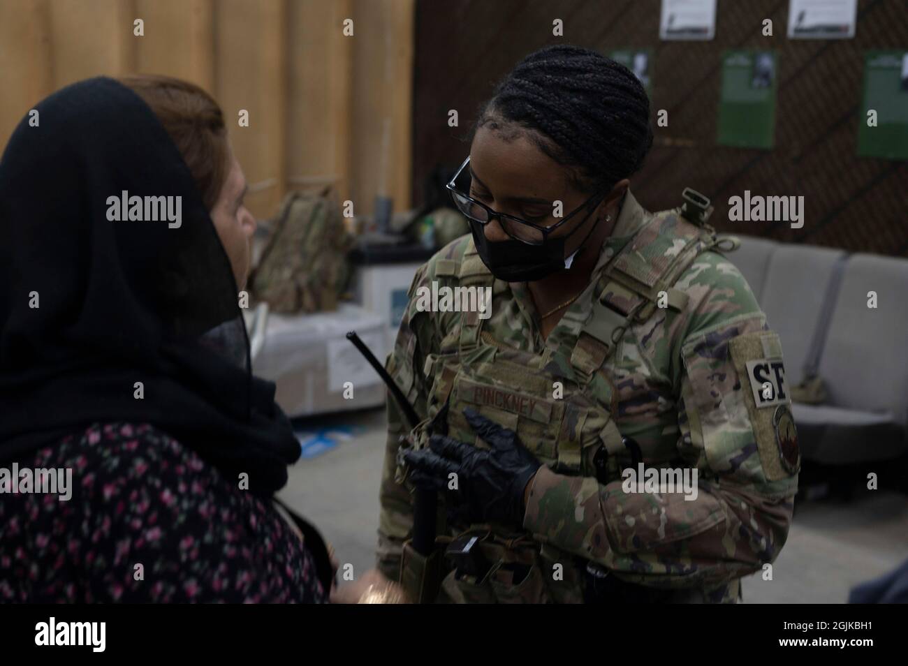 Emoni Pinckney, officier de 1re classe, affecté au 386e Escadron des forces de sécurité expéditionnaires, écoute un évacuateur afghan à la base aérienne Ali Al Salem, au Koweït, le 24 août 2021. Des membres du 386e Escadron des forces de sécurité expéditionnaires escortent les évacués de l'Afghanistan après être arrivés à bord d'un avion C-17 Globemaster III à la base aérienne Ali Al Salem (Koweït), le 24 août 2021. Le ministère de la Défense s'est engagé à appuyer l'évacuation des citoyens américains, des demandeurs de visa spécial d'immigration et d'autres personnes à risque de l'Afghanistan. (É.-U. Photo de la Force aérienne par Tech. Sgt. Eric Summers Jr.) Banque D'Images
