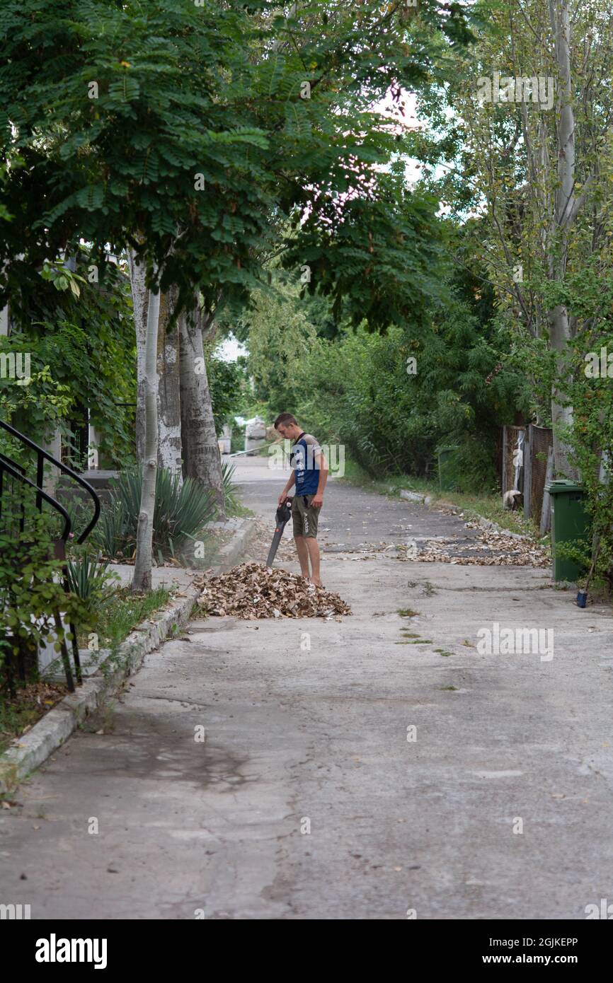 Zatoka, Odessa, Ukraine - 1 septembre 2021 Gardener enlève les feuilles avec un aspirateur de jardin Banque D'Images