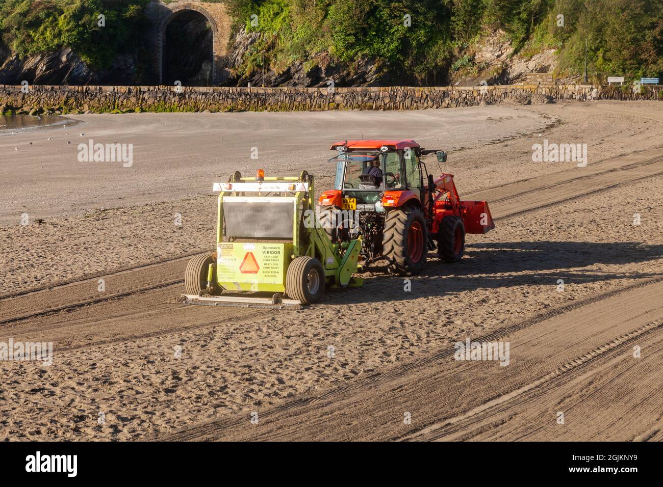 Nettoyage de la plage de la ville de Looe tôt un matin ensoleillé. Cornwall Royaume-Uni Banque D'Images