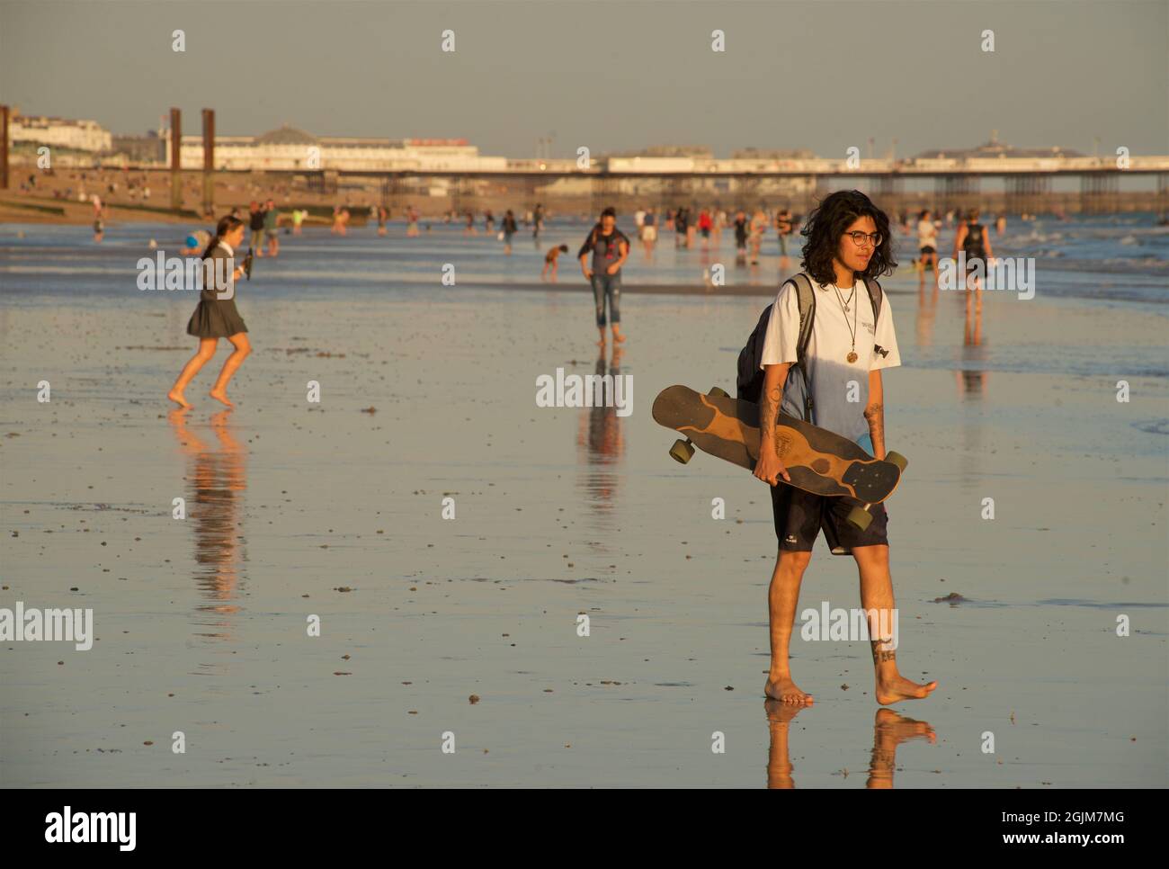 Adolescent avec un valet de planche à roulettes sur le sable à marée basse, Hove, Brighton & Hove, Royaume-Uni Banque D'Images