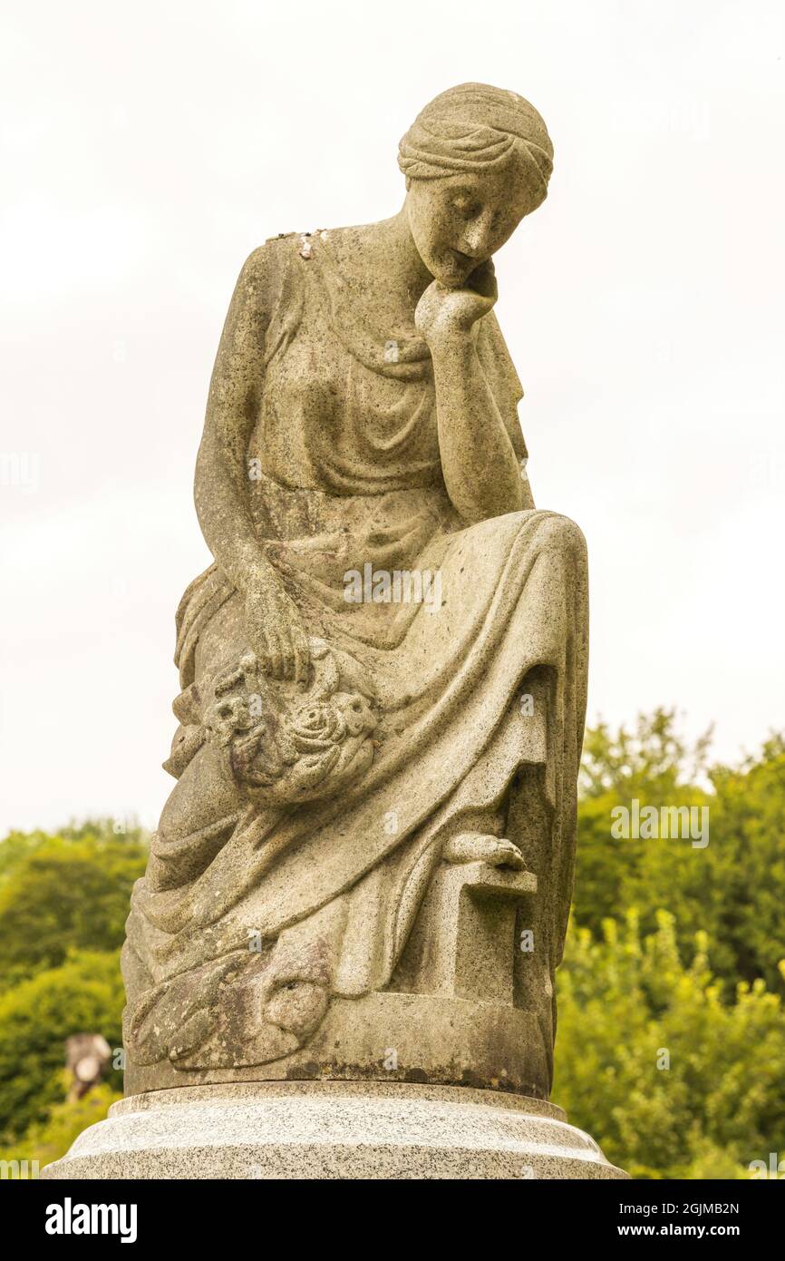 Une statue en pierre d'une femme assise avec sa tête reposant sur sa main, sur une tombe du cimetière d'Arnos Vale, Bristol UK, 02-09-2021. Banque D'Images