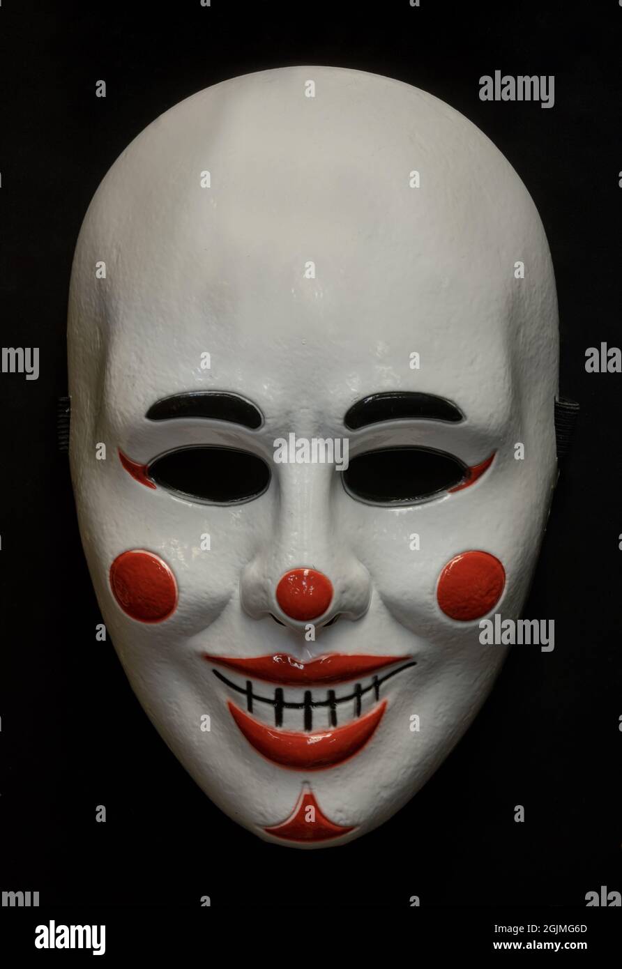 Demi-masque clown isolé contre un arrière-plan noir Banque D'Images