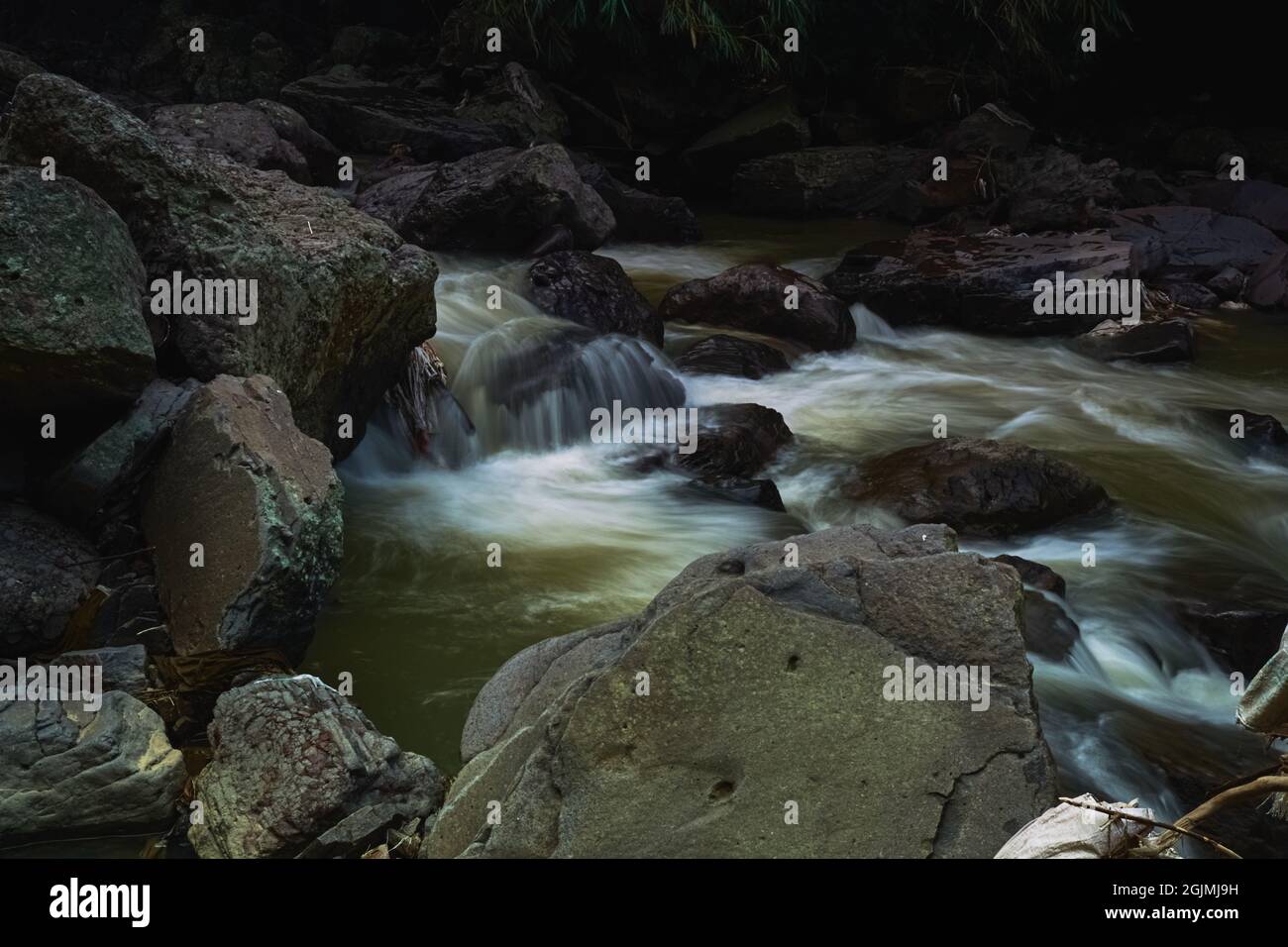 une chute d'eau dans la forêt avec un écoulement d'eau de précipitation et de grandes roches Banque D'Images