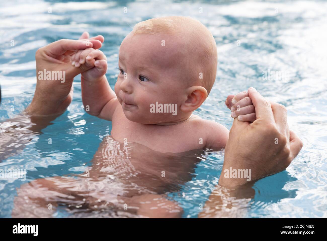Beau bébé garçon doux nageant dans la piscine tenant les mains des  pères.Sports de bébé, spa et loisirs.Un mode de vie sain, un bien-être  familial Photo Stock - Alamy