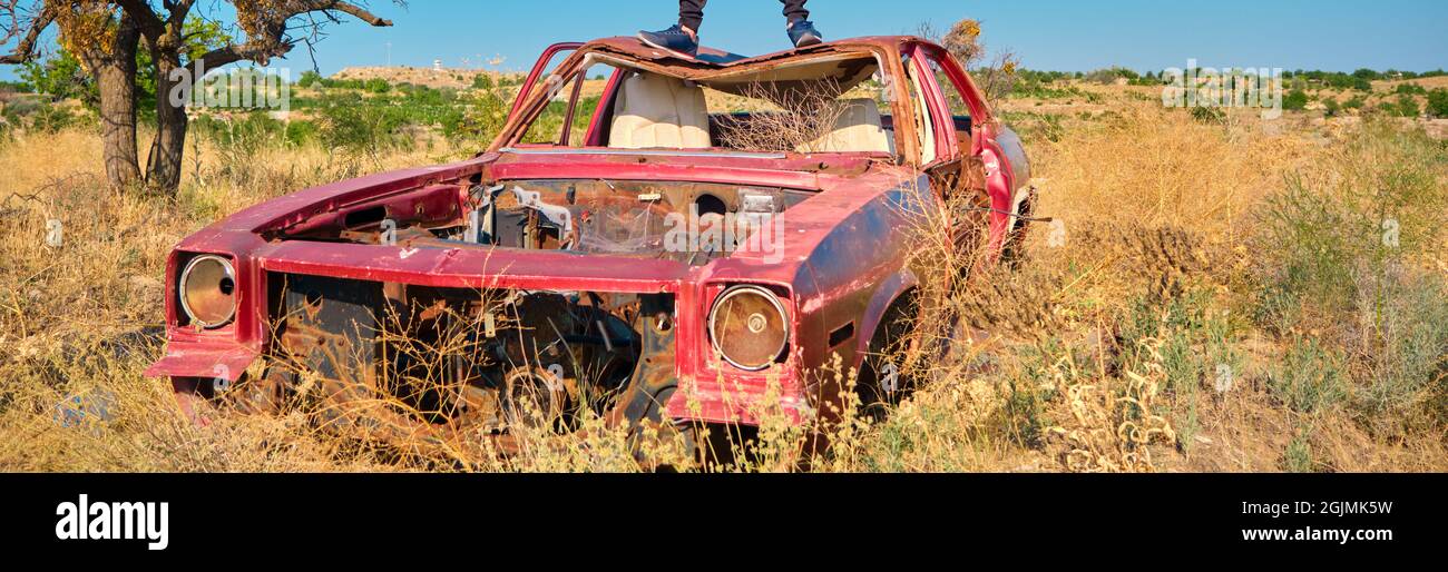 Voiture de style vintage abandonnée et de fard à sourcils sur un terrain agricole recouvert de plantes jaunes et d'herbe Banque D'Images