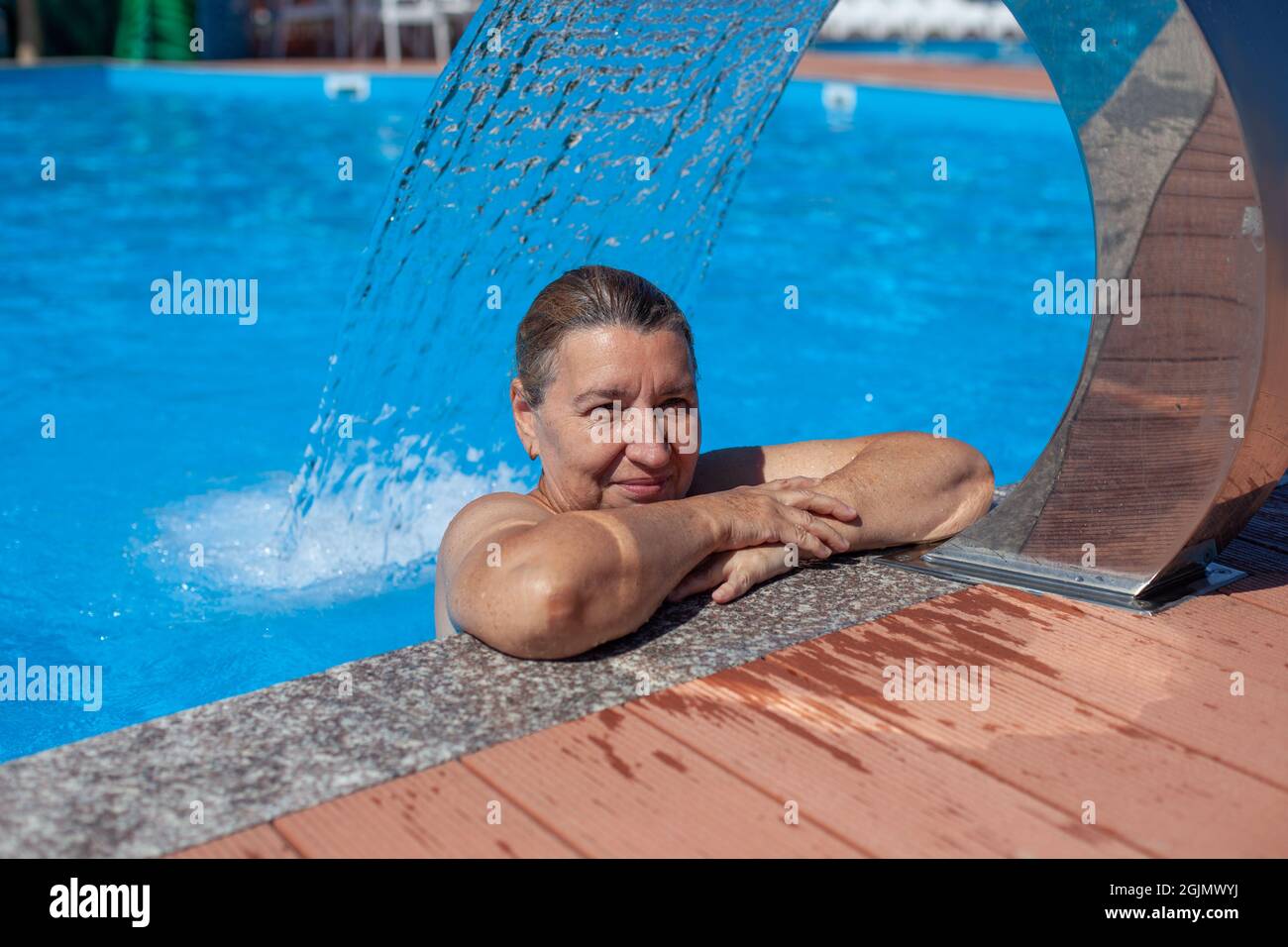 Centre thermal géothermique. Belle femme se repose et exécute la procédure d'hydro massage sous cascade à la station tropicale sur la mer Banque D'Images