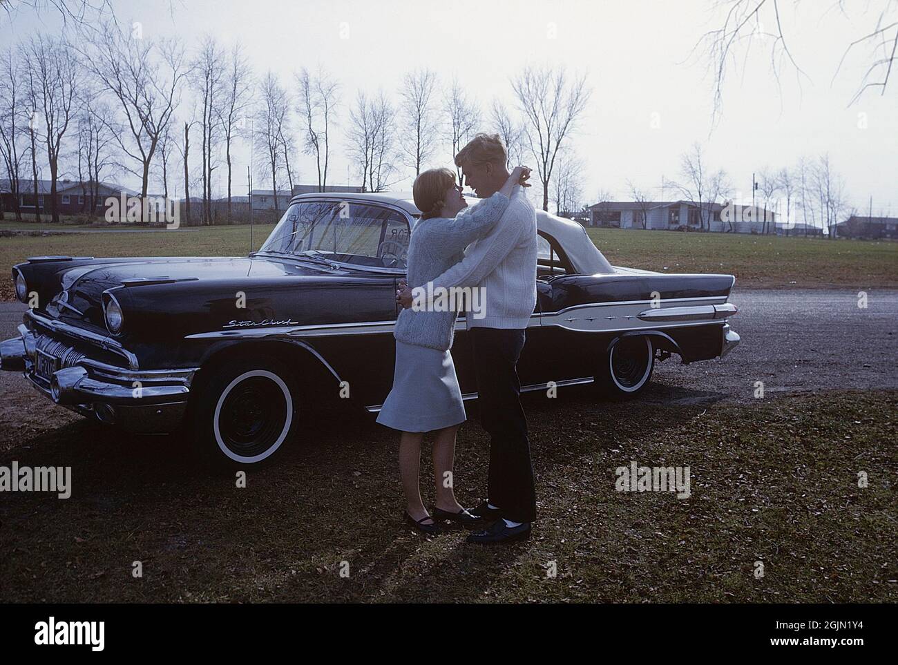 États-Unis dans les années 1960. Un jeune couple à côté d'un chef de Pontiac Star, un modèle qui a été fabriqué par Pontiac entre 1954 et 1966. La voiture a été facilement identifiée par sa garniture en étoile chromée le long de ses côtés. Original KODACHROME. Crédit Roland Palm réf. 6-9-18 Banque D'Images