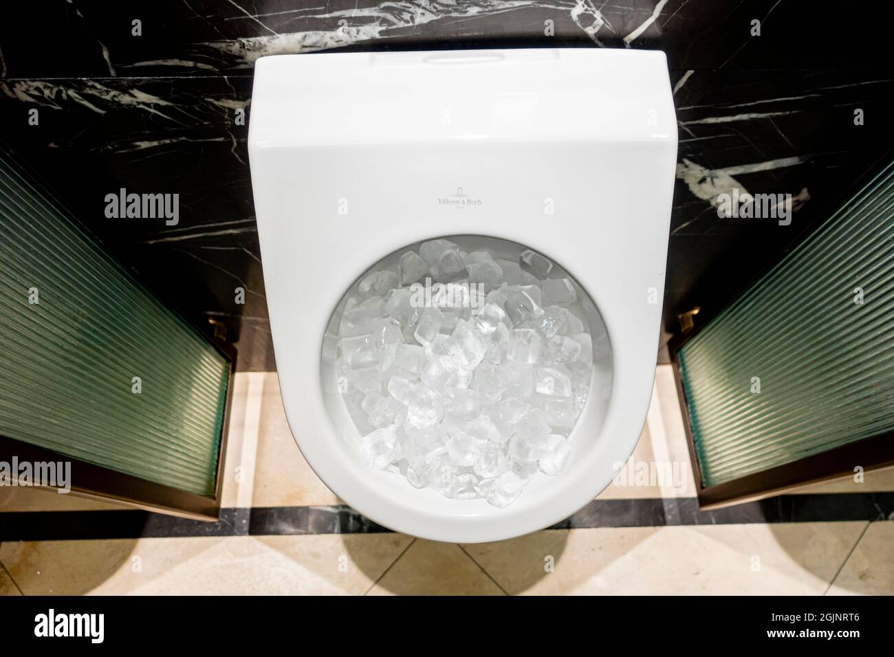 L'urinoir pour hommes Villeroy & Boch est rempli de glaçons dans une salle de bain dans le hall de l'hôtel de luxe Banque D'Images