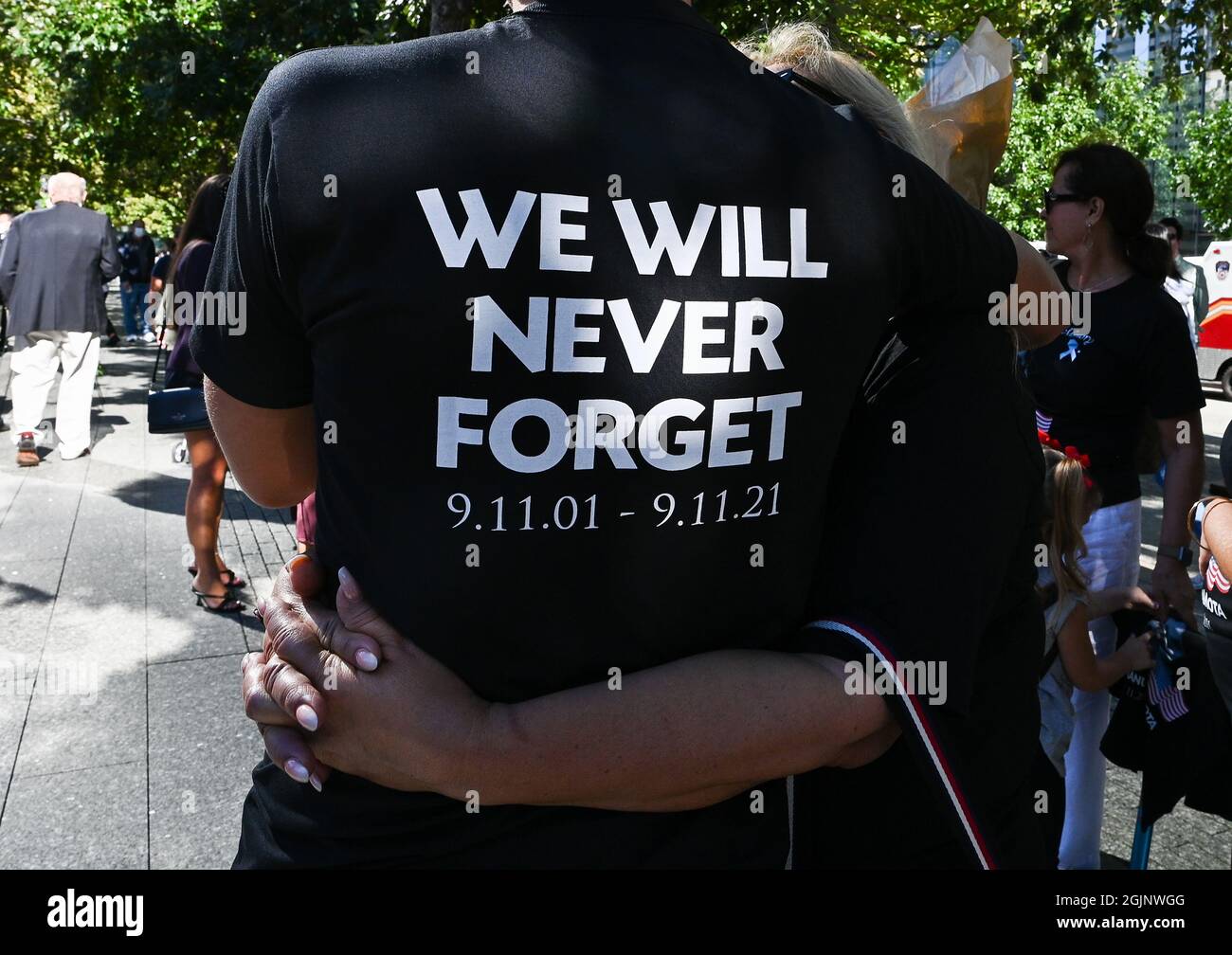 New York, États-Unis. 11 septembre 2021. Manuel DaMota porte une chemise  qui se lit comme « nous n'oublierons jamais 9.11.01-9.11.21 » alors qu'il  embrasse sa mère Barbara près du mémorial lors de