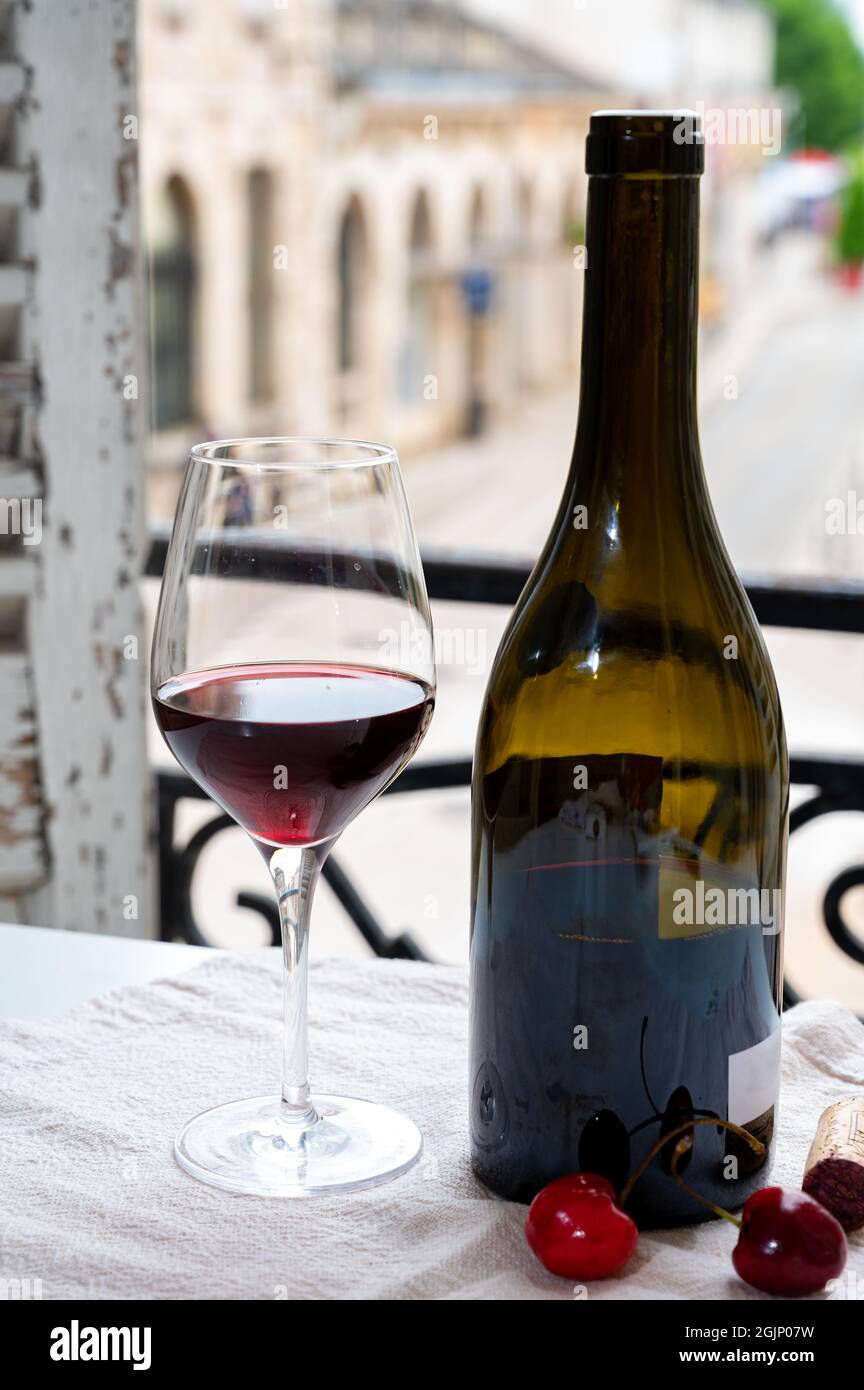 Dégustation de vin rouge bordeaux des grands vignobles cru Pinot noir, verre et bouteille de vin rouge et vue sur la vieille ville dans la région viticole de Bourgogne, F Banque D'Images