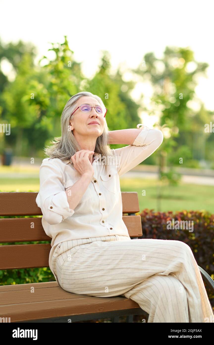 Bonne femme adulte ayant le repos dans le parc Banque D'Images