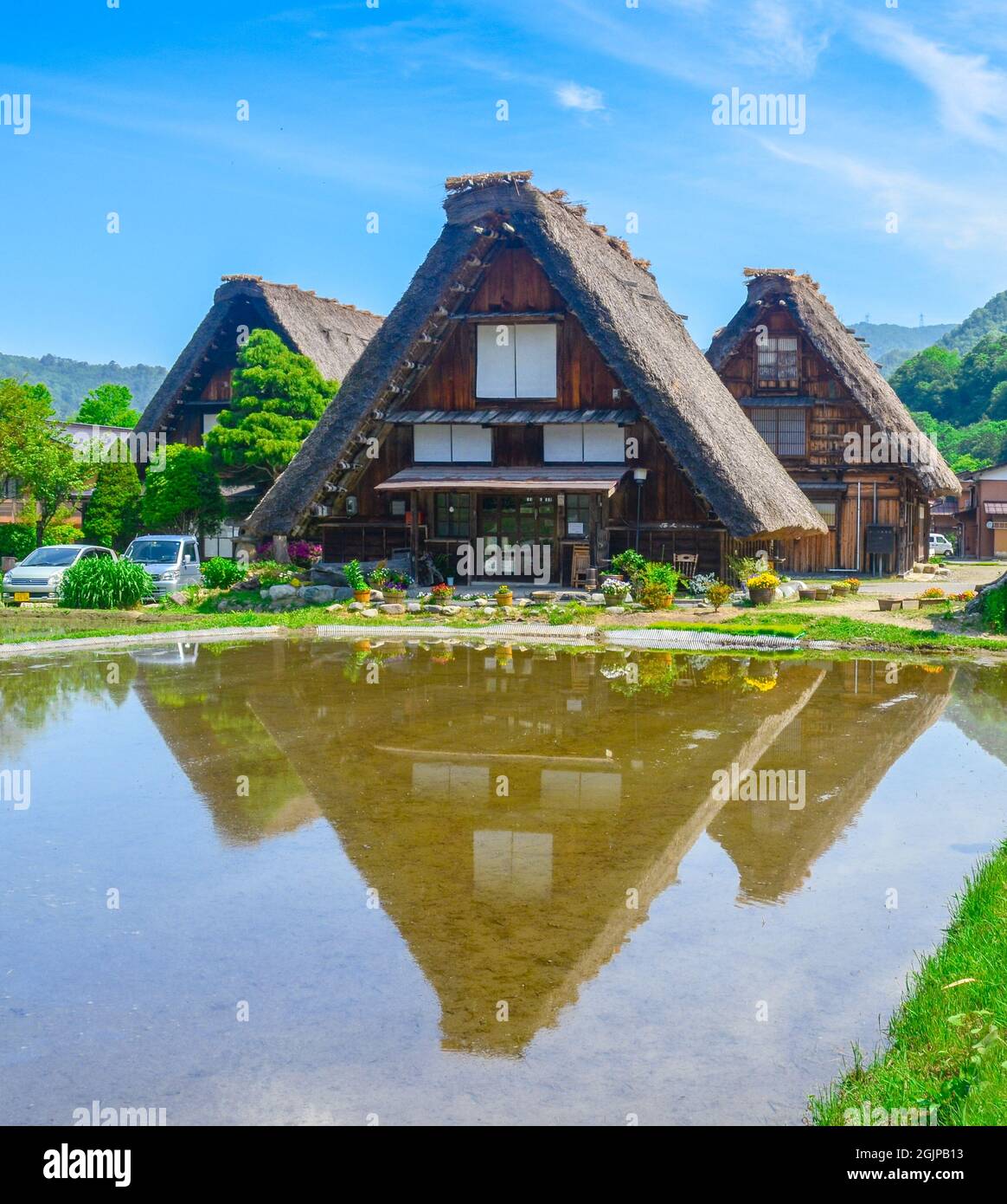 Belle maison de style Gassho zukuri traditionnelle de printemps avec réflexion d'eau dans le village de Shirakawa-Go, préfecture de Gifu, Japon. Un culte mondial de l'UNESCO Banque D'Images
