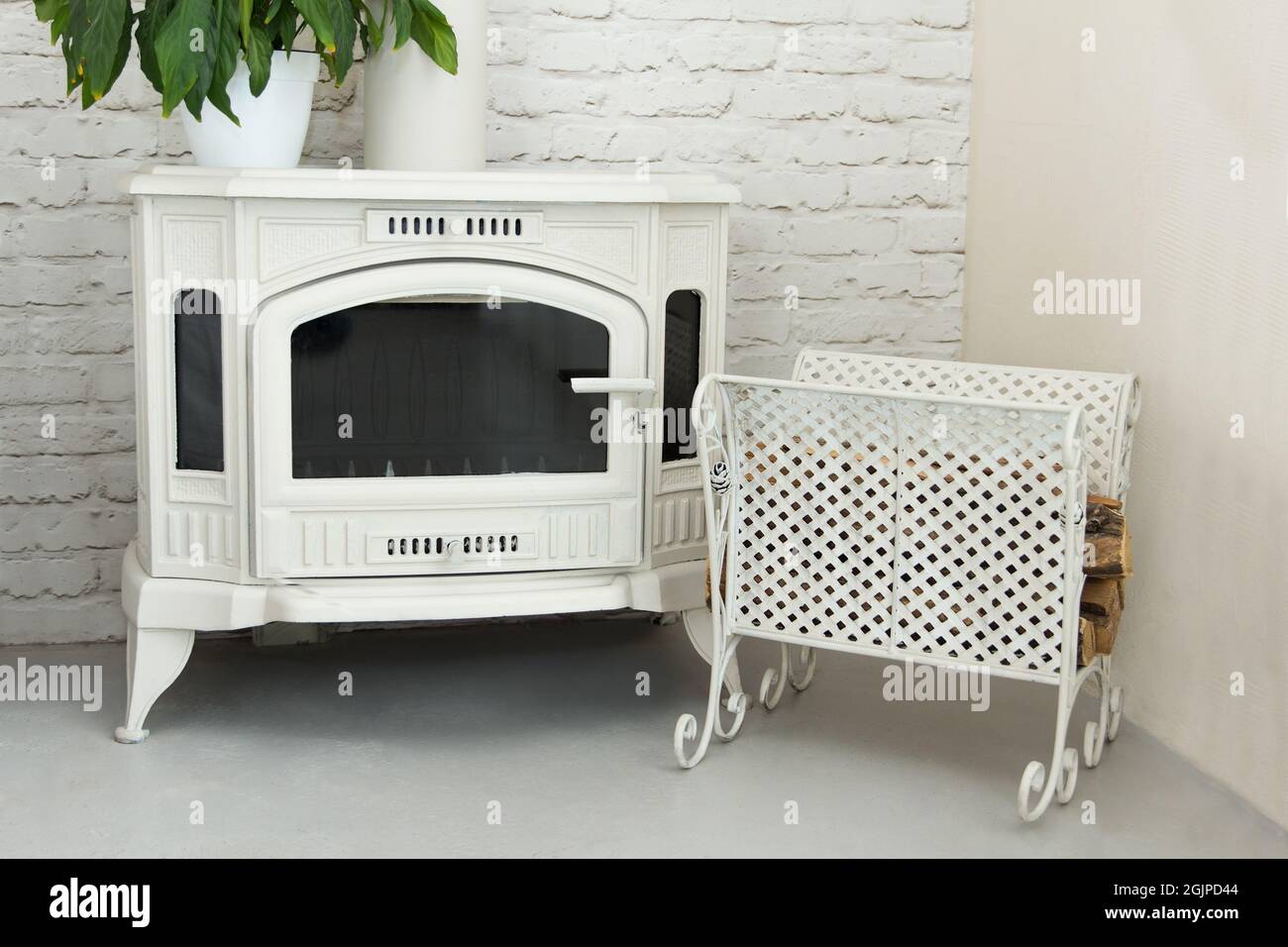 Nouvelle belle cheminée sur bois blanc de couleur située dans la chambre avec une palette en métal forgé Banque D'Images
