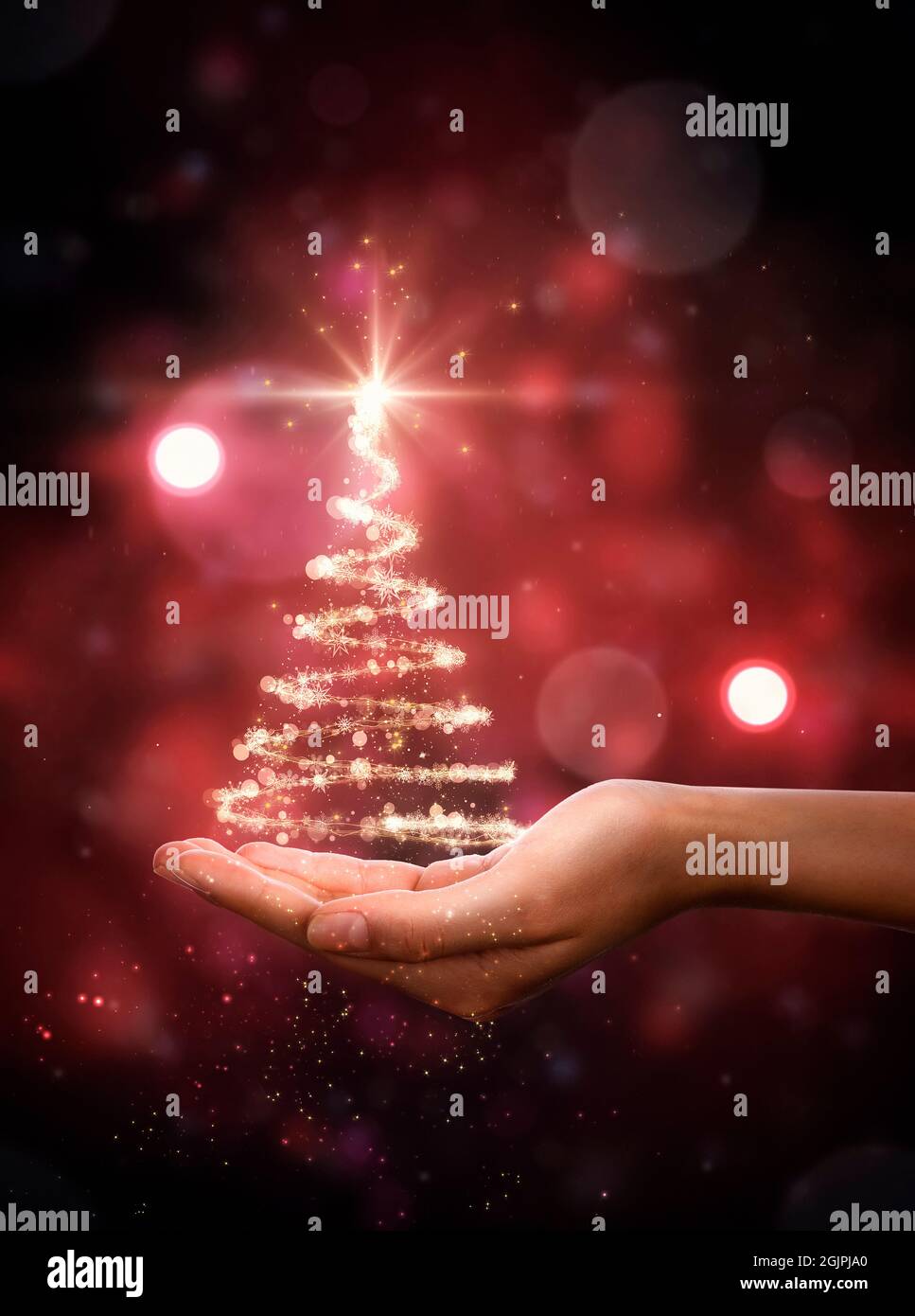 Arbre de Noël rouge à la main. Sapin de Noël, belles lumières, étoiles et flocons de neige Banque D'Images