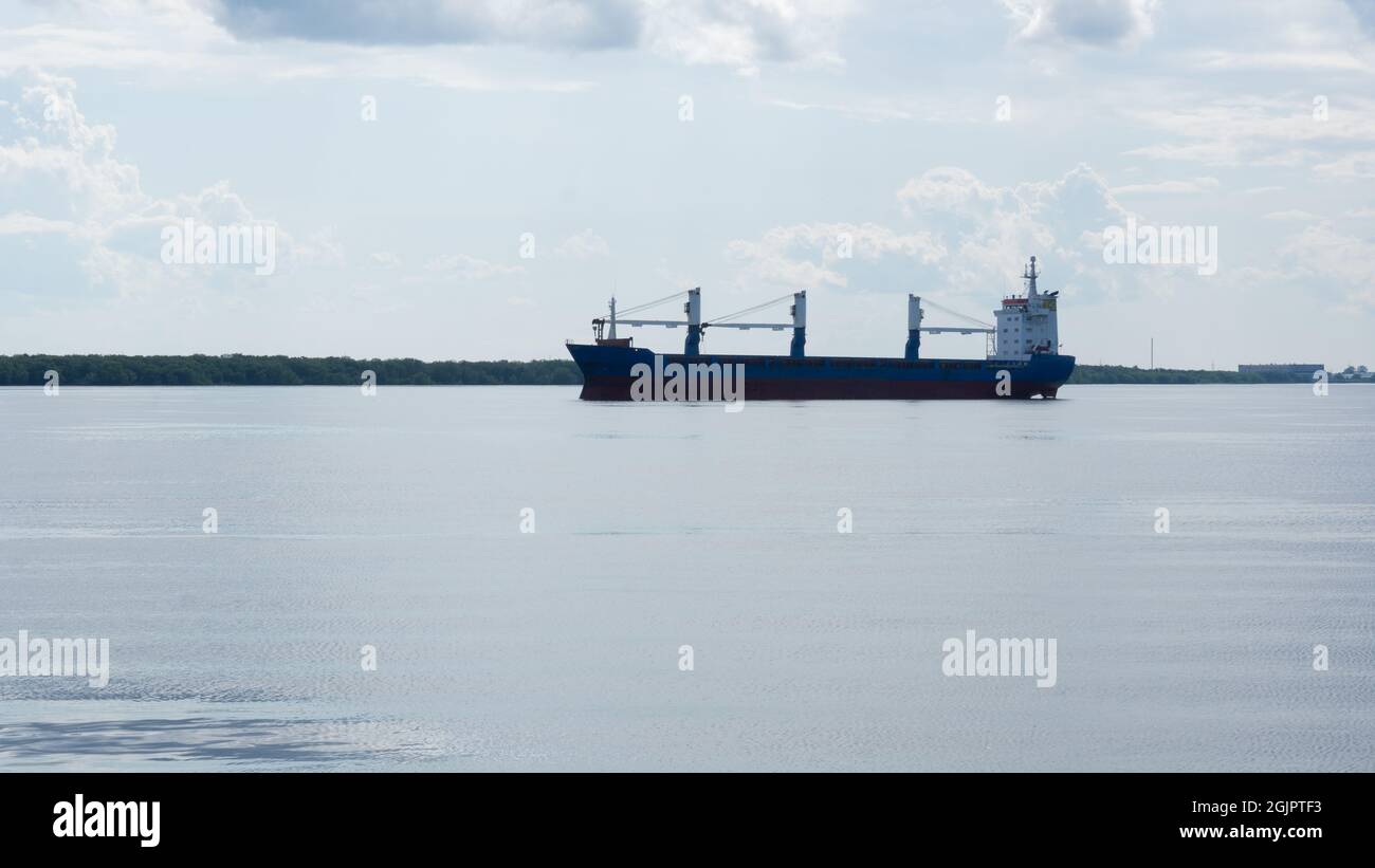 Un gros cargo quitte le port et flotte le long de la rivière. Transport de marchandises, communications mondiales, transport, logistique Banque D'Images