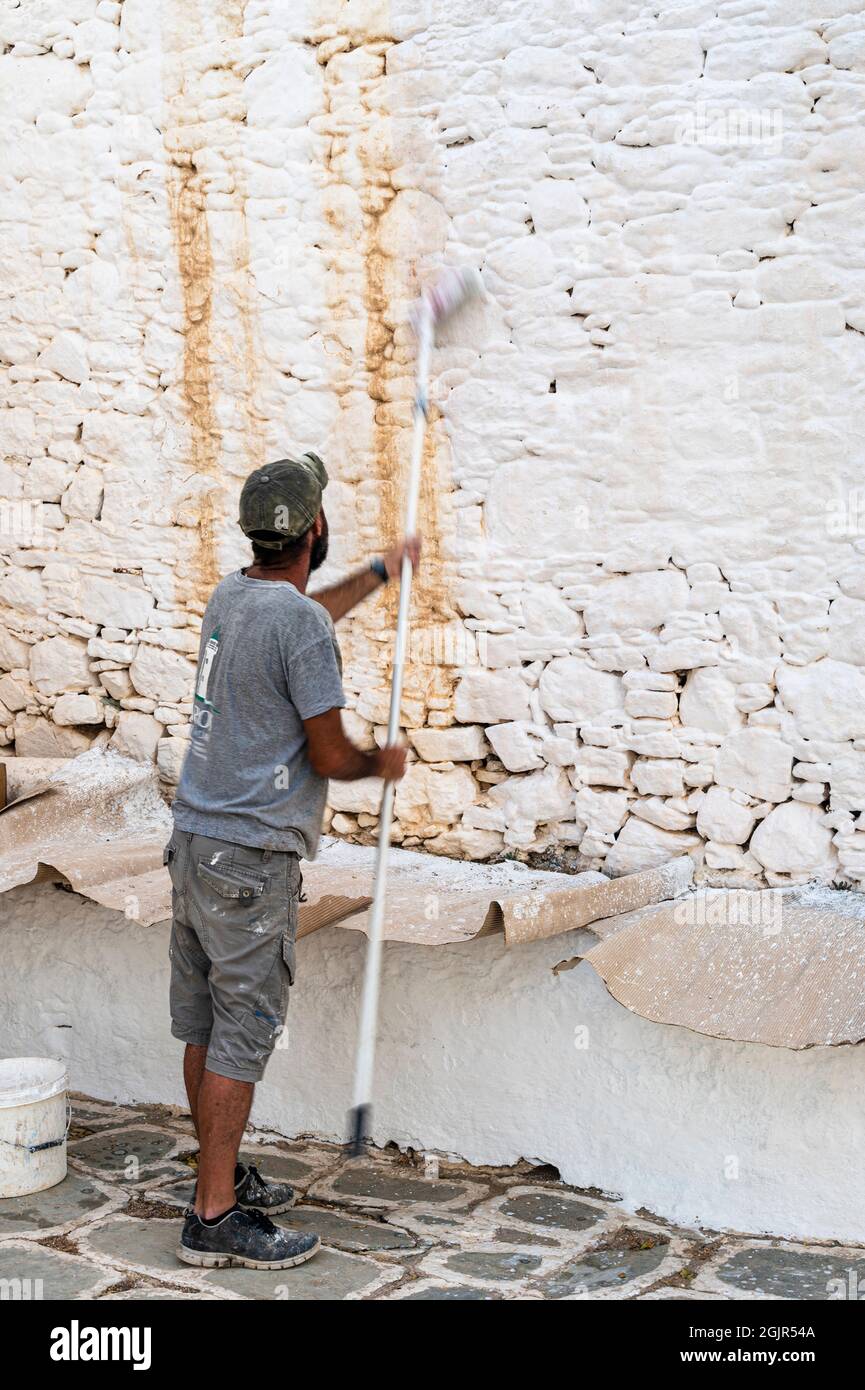 Homme blanc lavant les murs de l'église de Panagia Banque D'Images