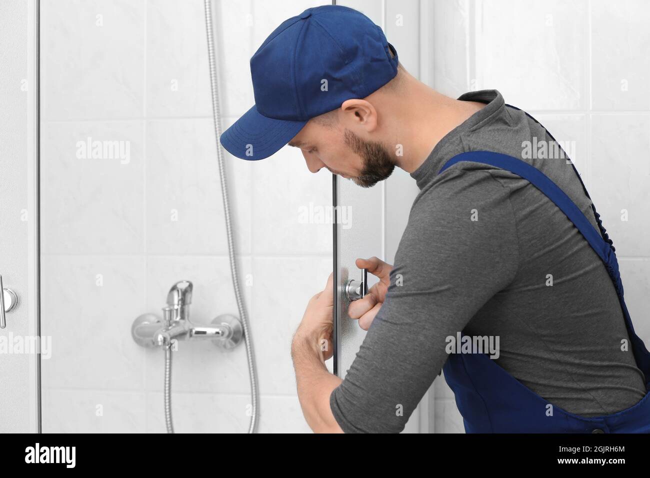 Jeune homme la réparation de porte de cabine de douche dans salle de bains  Photo Stock - Alamy