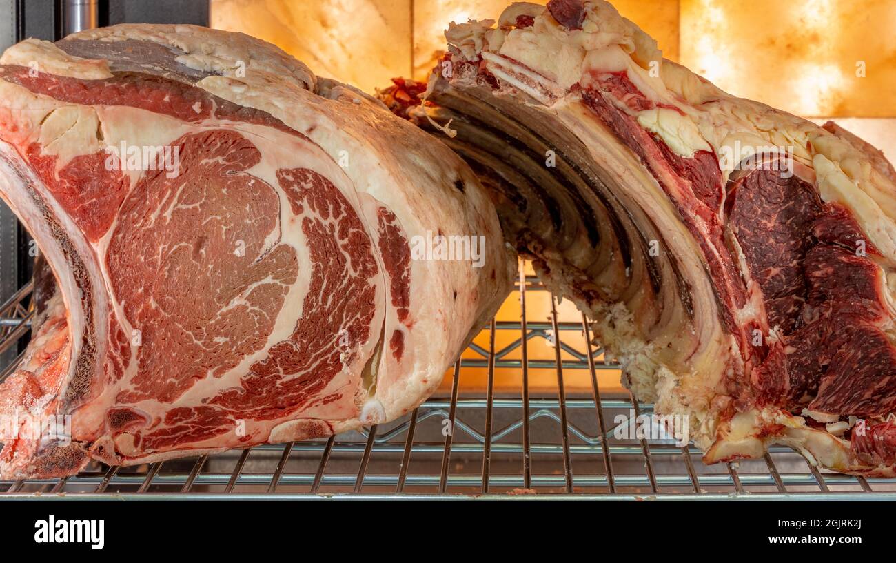 Steak de bœuf dans une armoire de vieillissement de viande séchée. Grillades au réfrigérateur dans un délicieux restaurant gastronomique. Sécher la viande vieillissante en chambre froide. Coupe séchée Banque D'Images