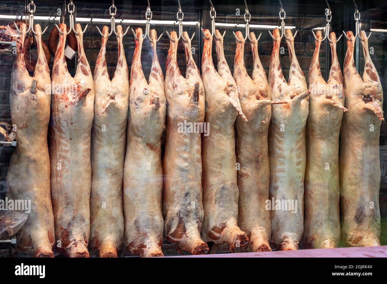 Viande de carcasse d'agneau accrochée à des crochets dans l'abattoir, boucherie sont dans l'armoire du réfrigérateur. Viande d'agneau non cuite crue Banque D'Images