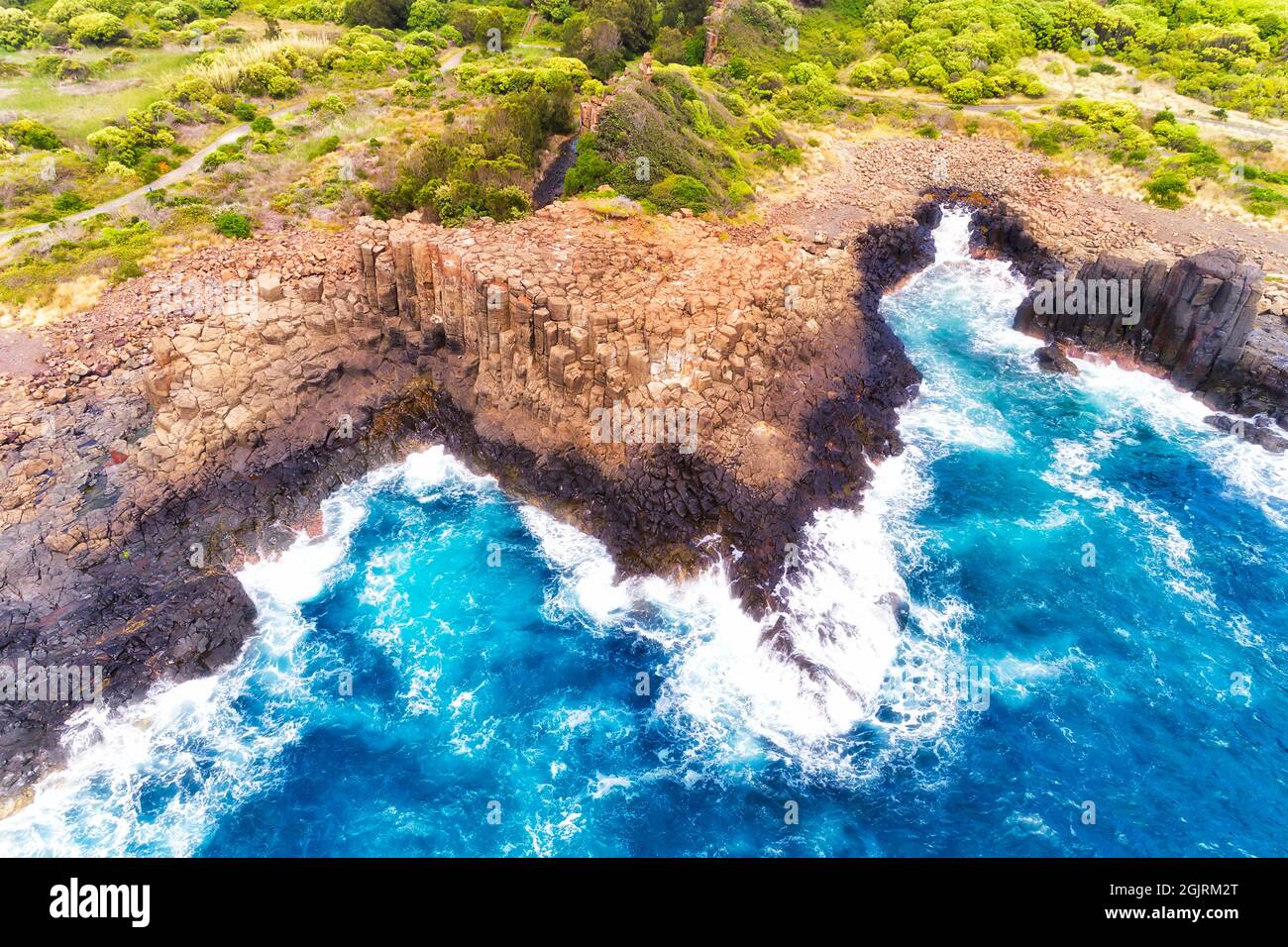 Colonnes de basalte dans la carrière de Bombo sur la côte australienne sur l'océan Pacifique - vue aérienne de haut en bas. Banque D'Images