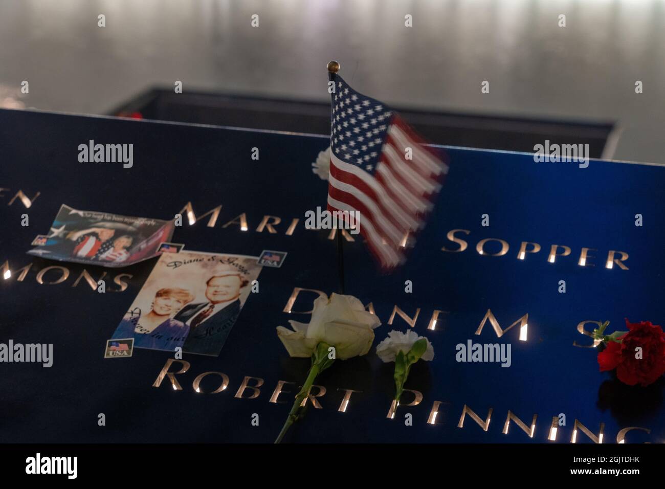 NEW YORK, NY - SEPTEMBRE 11 : fleurs et drapeau américain laissés en l'honneur des noms des personnes qui ont péri pendant la tragédie sont vus au National septembre 11 Memorial and Museum le 20e anniversaire de l'attaque terroriste le 11 septembre 2021 à New York City. Banque D'Images